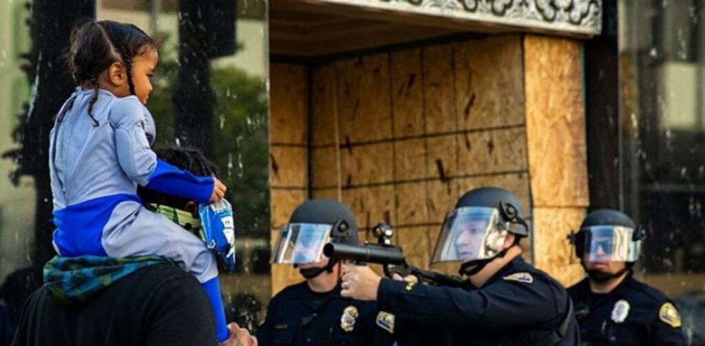 Συγκλονιστικό καρέ από τις ΗΠΑ: Αστυνομικός σημαδεύει με το όπλο του μικρό κοριτσάκι (Photo) - Media