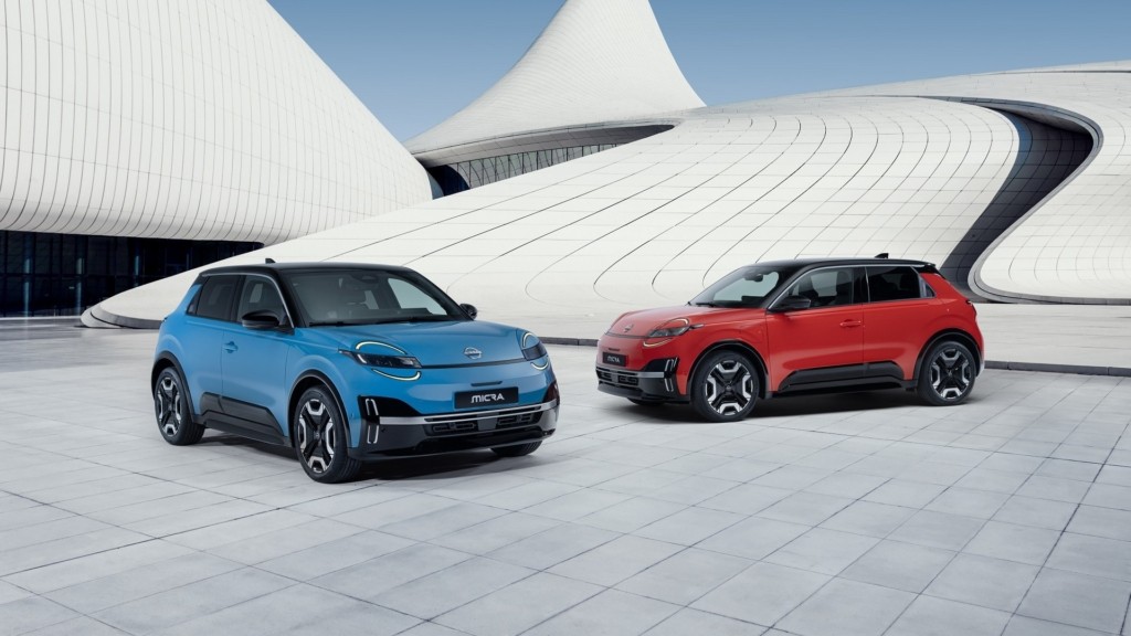 two iconic Micras – gear blue color and red color – parked in front of a blue & white design architectural building in a V shape facing each other